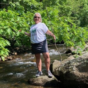 Photo of Patty Yewcic (President) in a stream.